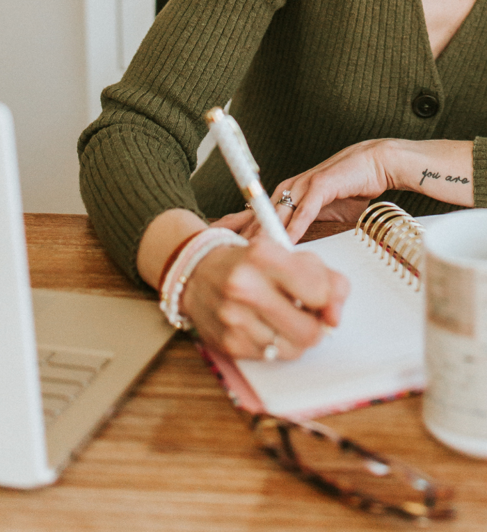 Female entrepreneur's hands holding pen and working